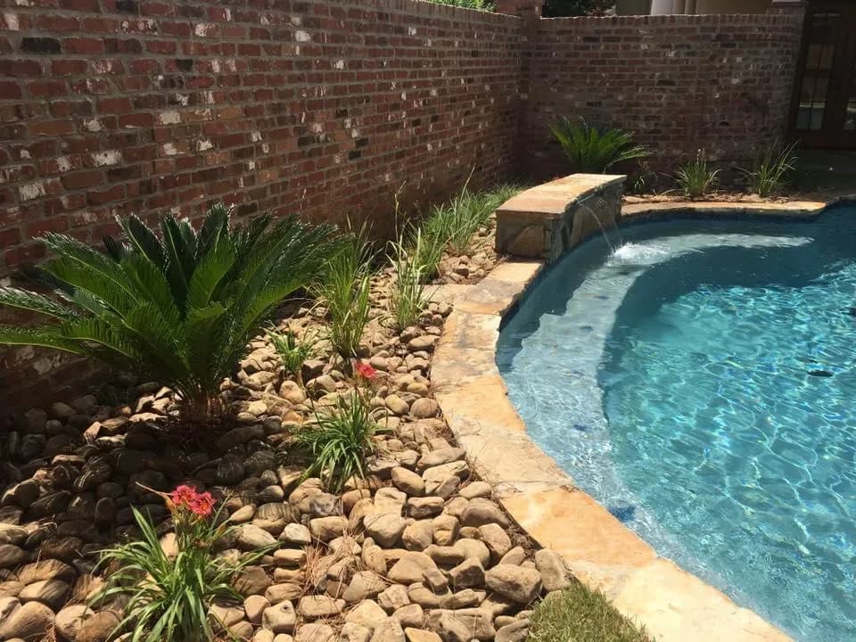 Poolside planting with river rock border