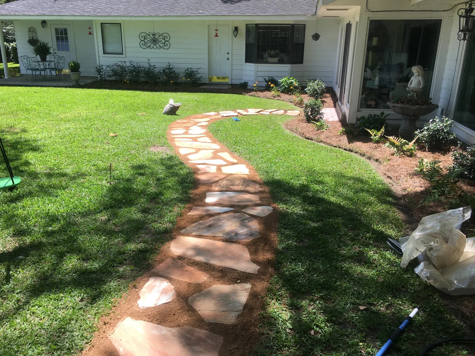 Flagstone path curving through a freshly planted front yard